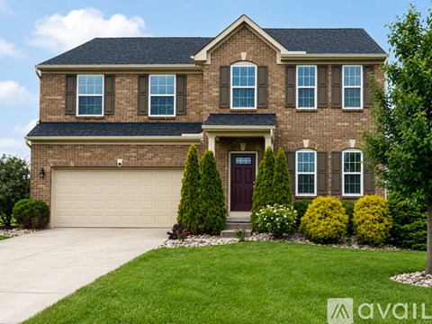 A large house with a brown brick exterior and a dark brown door.