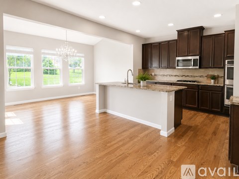 A modern kitchen with dark brown cabinets and a white island.