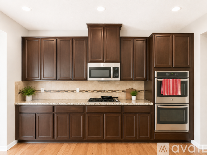 A kitchen with brown cabinets and a stainless steel oven.