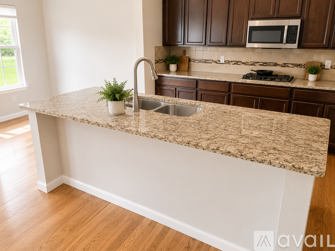 A kitchen with a granite countertop and wooden cabinets.