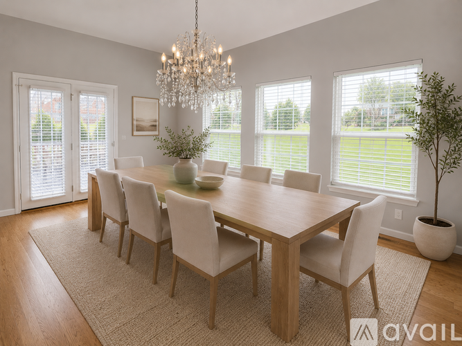 A dining room with a large table and chairs.