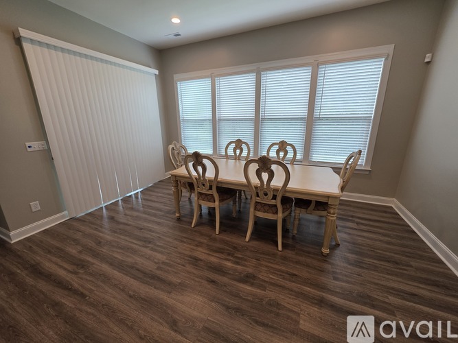 A dining room with a table and chairs.