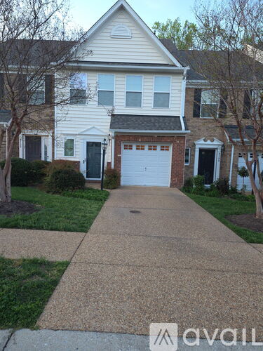A white house with a garage door and a driveway.