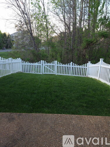 A white picket fence encloses a green lawn.