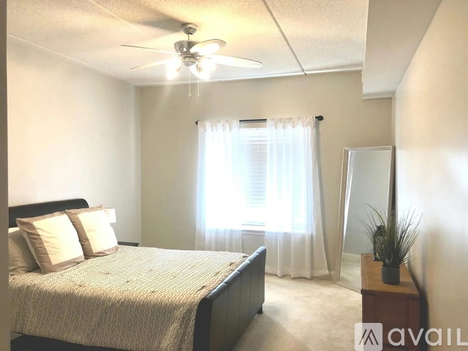 A bedroom with a bed, dresser, and window.
