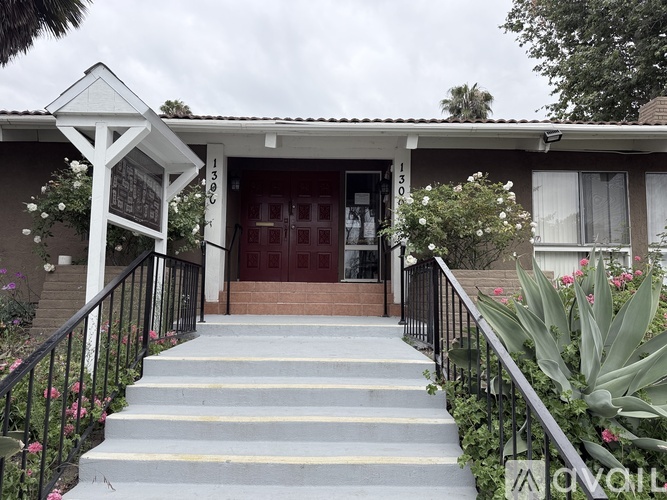 A house with a red door and a black railing.