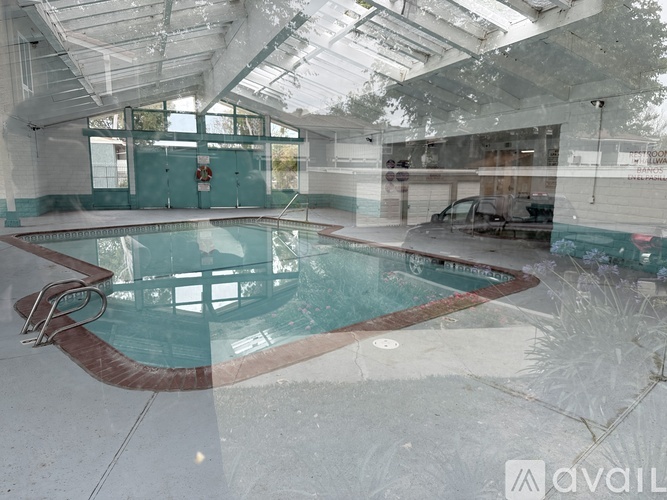 A large indoor swimming pool with a glass wall surrounding it.