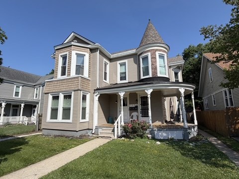 A house with a turret and a porch.