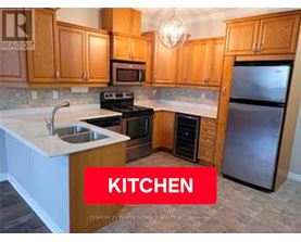 A kitchen with wooden cabinets and a stainless steel refrigerator.