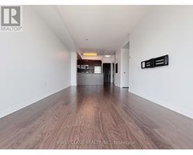 A long hallway with wood floors and white walls.