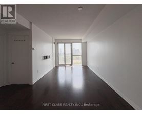 A long hallway with wood floors and white walls.