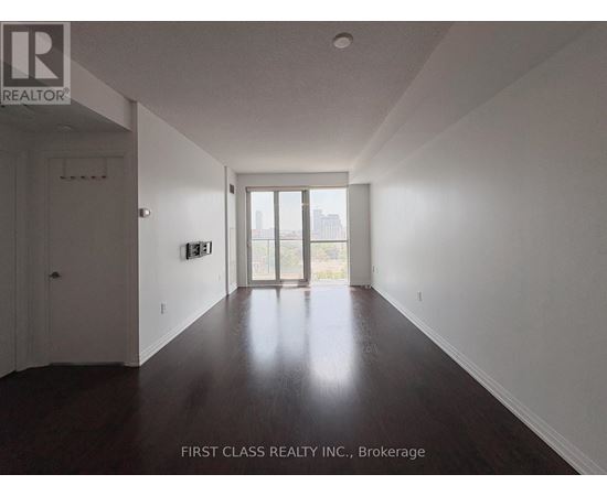 A long hallway with wood floors and white walls.