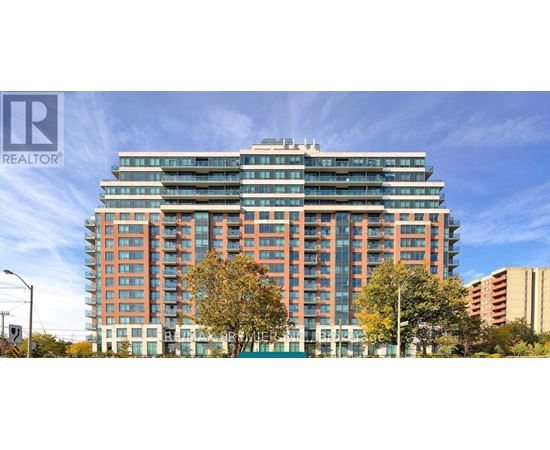 A tall building with many windows is surrounded by trees.