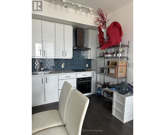A kitchen with white cabinets and a black countertop.