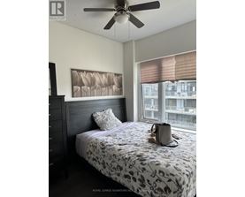 A bedroom with a bed, a ceiling fan, and a window with blinds.