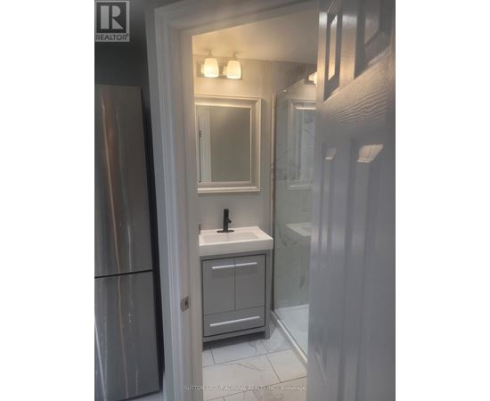 A bathroom with a sink, mirror, and cabinet.