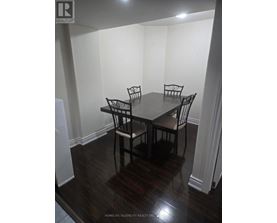 A dining room with a table and chairs.