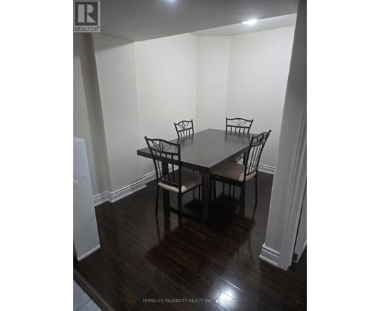 A dining room with a table and chairs.