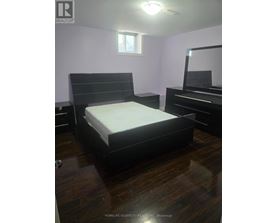 A bedroom with a bed, dresser, and mirror.