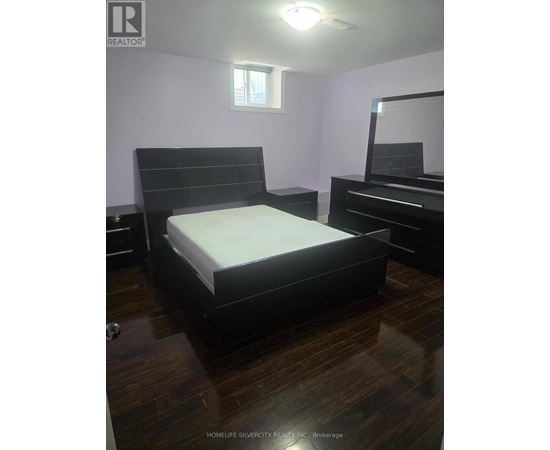 A bedroom with a bed, dresser, and mirror.