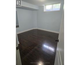 A room with wooden flooring and white walls.