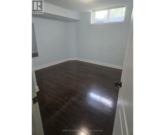 A room with wooden flooring and white walls.