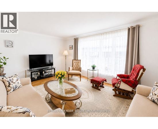 A living room with a sofa, a coffee table, a television, and a window with curtains.