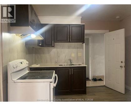 A kitchen with a white stove and black cabinets.
