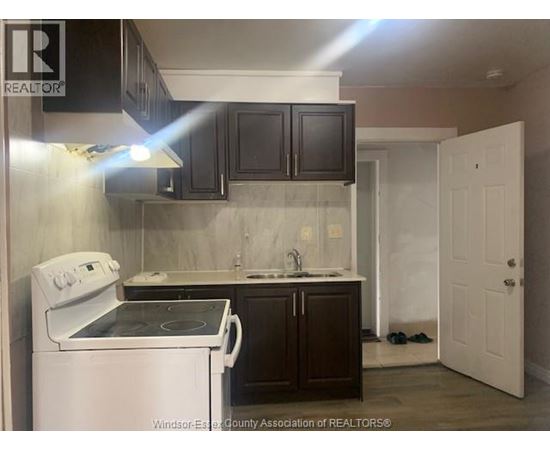A kitchen with a white stove and black cabinets.