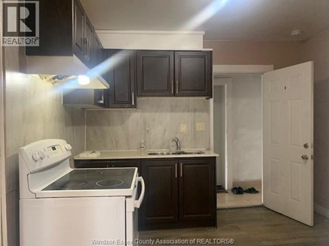 A kitchen with a white stove and black cabinets.