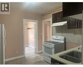 A kitchen with a refrigerator, stove, and sink.