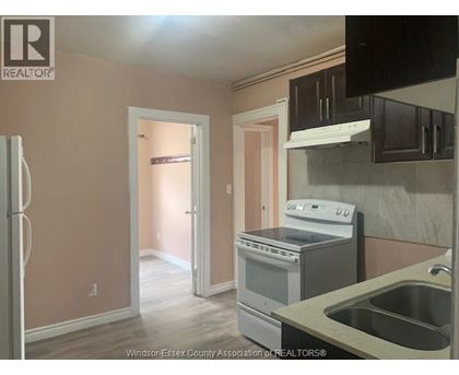 A kitchen with a refrigerator, stove, and sink.