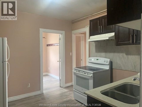 A kitchen with a refrigerator, stove, and sink.