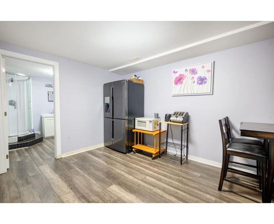 A kitchen with a fridge, a table and a chair.