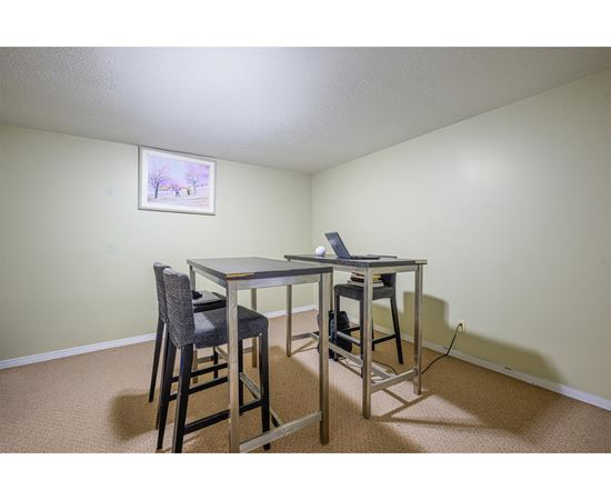 A dining room with a table and chairs.