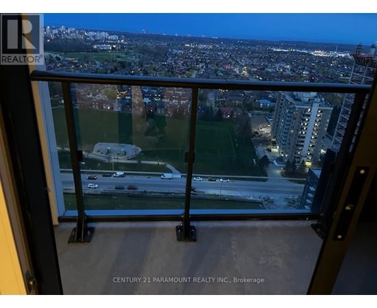 A view from a balcony overlooking a city at night.