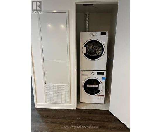 A white washing machine is in a white cabinet.
