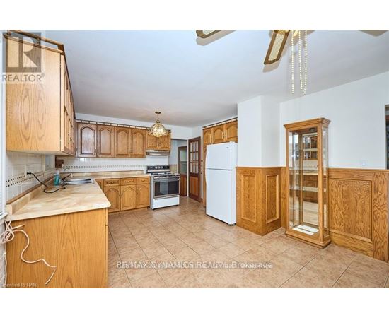 A kitchen with wooden cabinets and a white refrigerator.