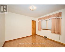 A room with a wooden door and a window with curtains.