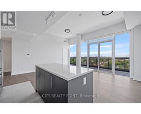 A modern kitchen with a large island and a view of the city.
