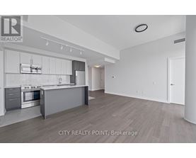 A modern kitchen with white cabinets and stainless steel appliances.