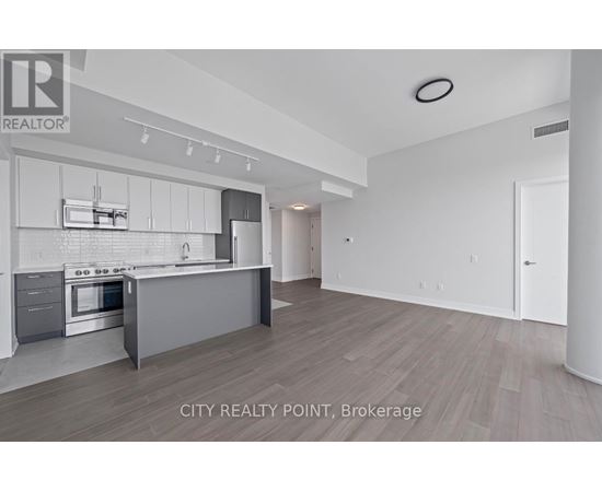 A modern kitchen with white cabinets and stainless steel appliances.