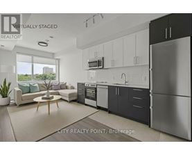 A modern kitchen with a refrigerator, oven, and sink.