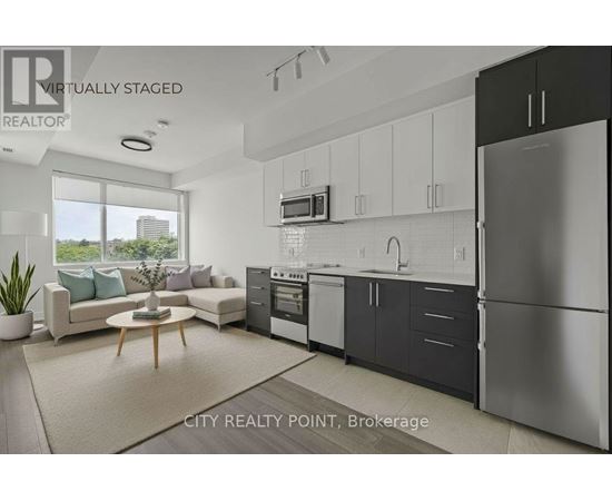 A modern kitchen with a refrigerator, oven, and sink.