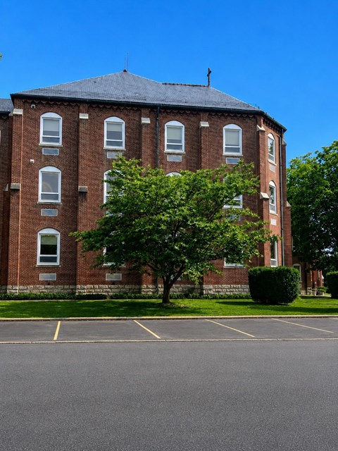 A large red brick building with a tree in front of it.