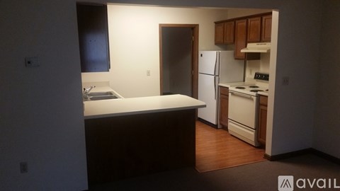 A kitchen with a refrigerator, stove, and sink.