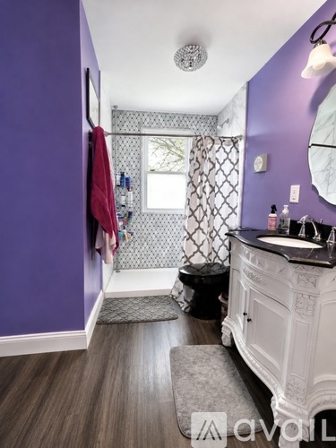 A bathroom with purple walls and a white vanity.