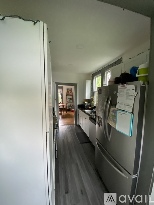 A kitchen with a white refrigerator and a white door.