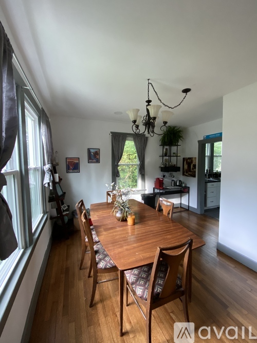 A dining room with a wooden table and chairs.