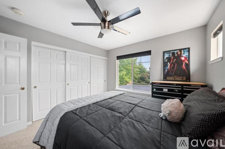 A bedroom with a large bed and a ceiling fan.
